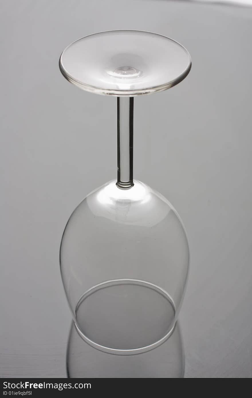 Transparent empty wine glass isolated on glass background