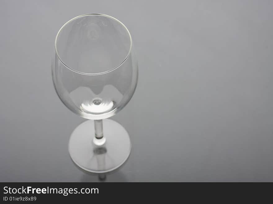 Transparent empty wine glass on glass background