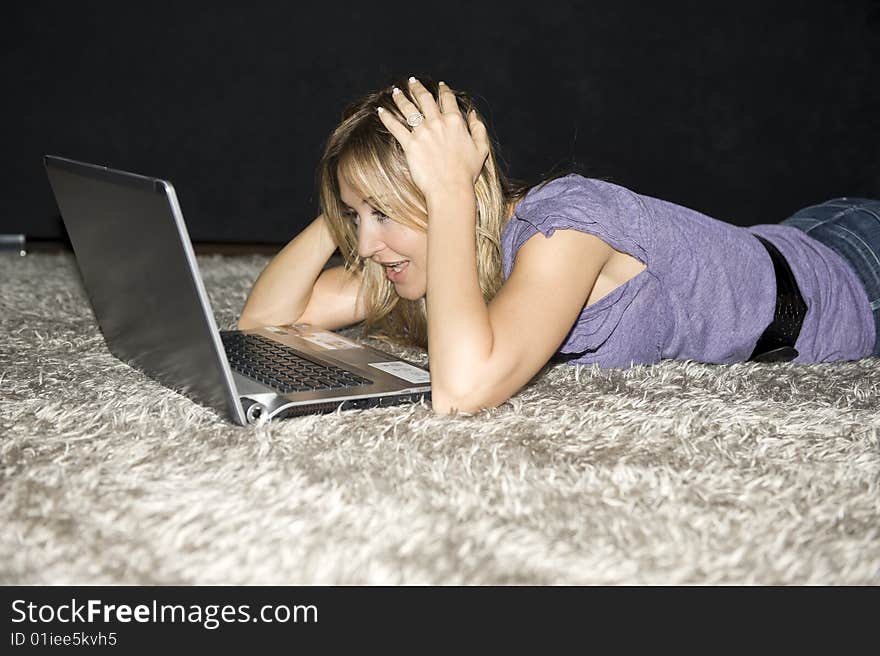 Woman laying down and working on a laptop computer at home. Woman laying down and working on a laptop computer at home