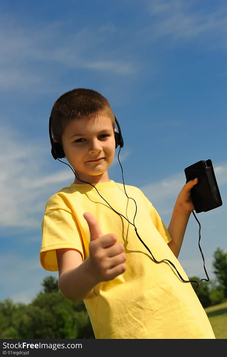 The boy listening to music in the headphones. The boy listening to music in the headphones