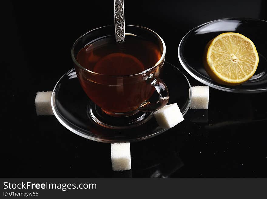 A glass cup of tea with a lemon and sugar. A glass cup of tea with a lemon and sugar