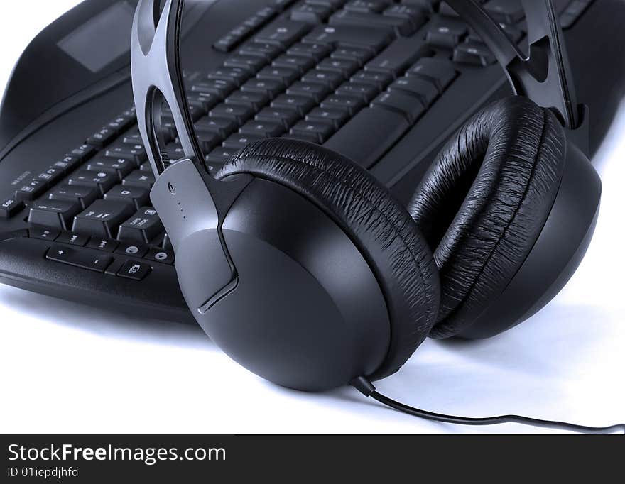 Close up of keyboard and headphones on white background