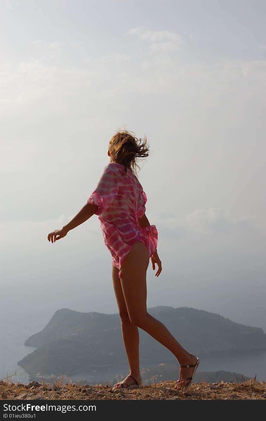 Young girl on the edge of a high cliff, wind blowing, Kefalonia (Cephalonia)Island, Greece. Young girl on the edge of a high cliff, wind blowing, Kefalonia (Cephalonia)Island, Greece