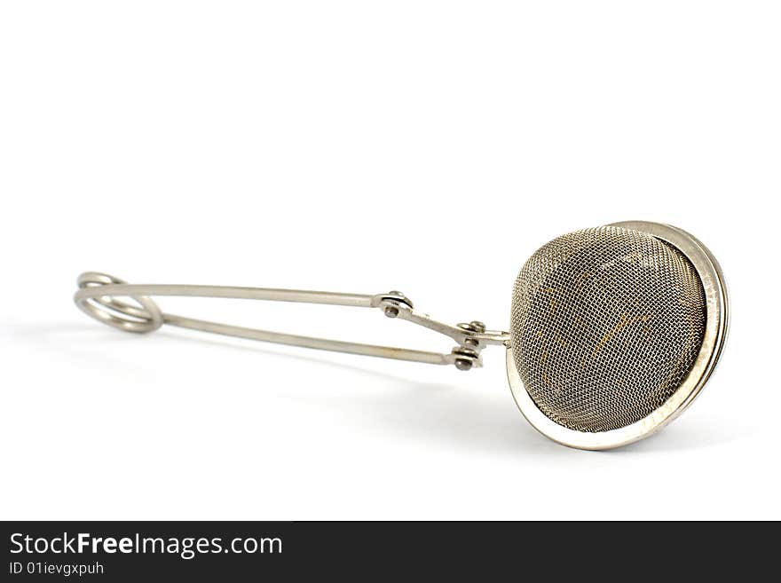 Tea strainer with tea inside isolated on white.