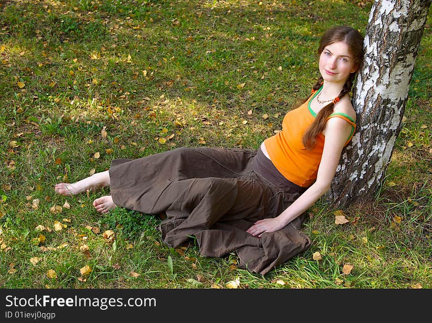 Pregnant girl sitting under a tree