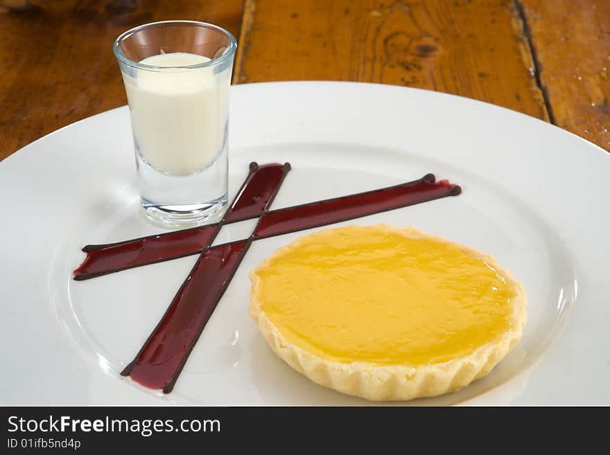 Delicious lemon tart with cream jar and decoration on plate