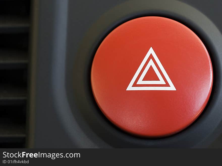 A hazard warning flasher button from a car dashboard. A hazard warning flasher button from a car dashboard