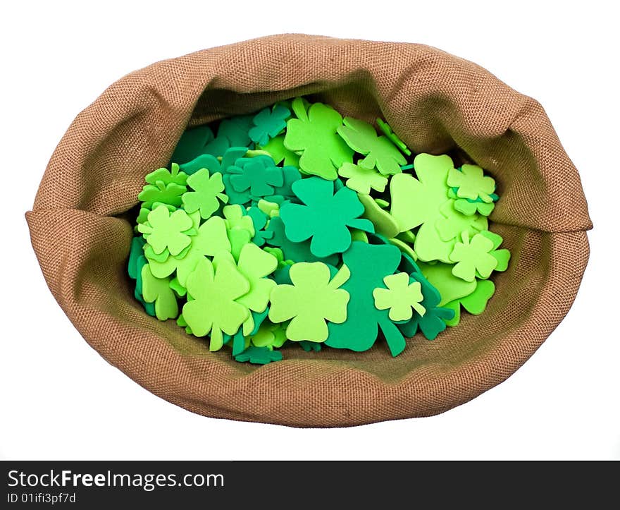 Bag of craft shamrocks on white background.