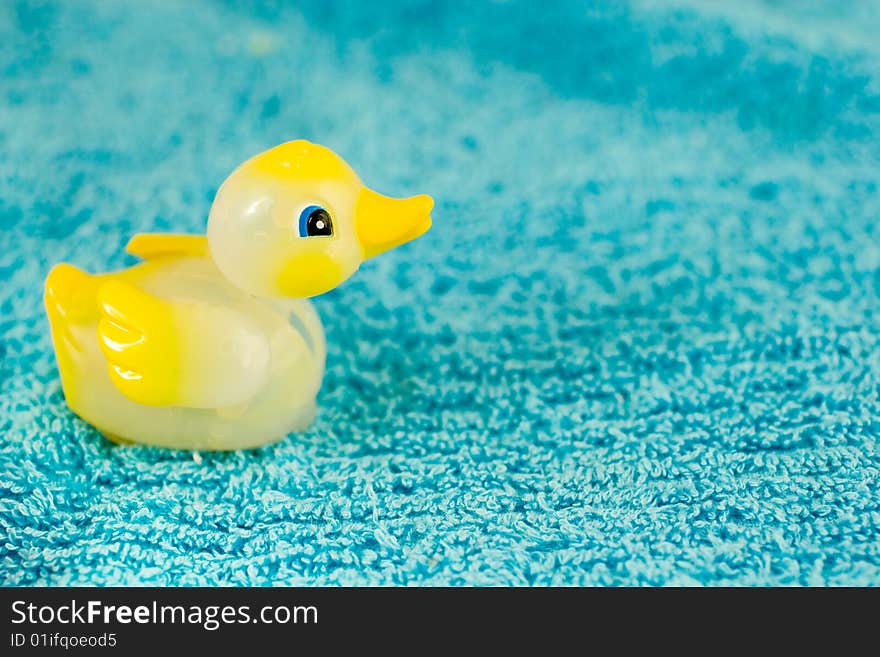 Yellow plastic ducky toy on a blue towel