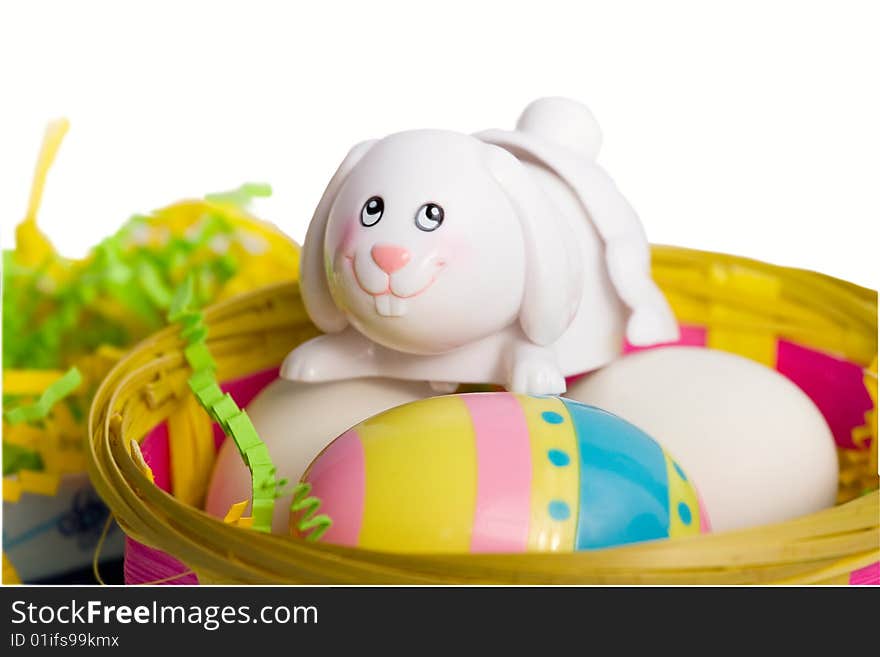 White Easter bunny in a basket with eggs, isolated on white