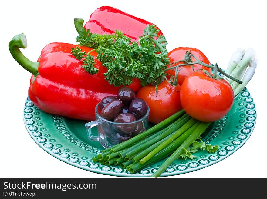 Red bell peppers, tomatoes, green onions and olives on a green plate, isolated on white. Red bell peppers, tomatoes, green onions and olives on a green plate, isolated on white