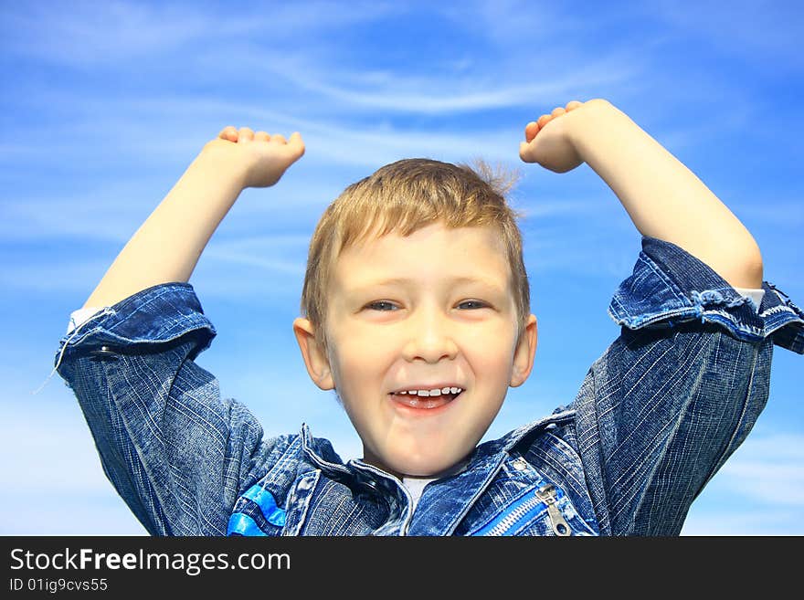 The little boy on the blue sky background. The little boy on the blue sky background