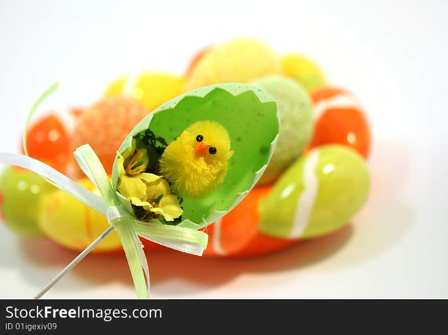 Yellow toy easter chick hatching out of an egg shell