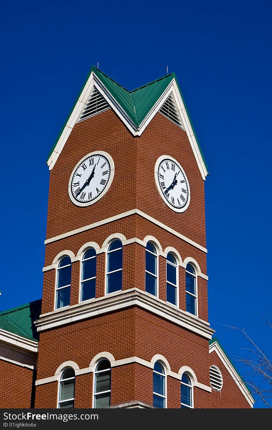 A beautiful brick tower with a clock against blue sky. A beautiful brick tower with a clock against blue sky