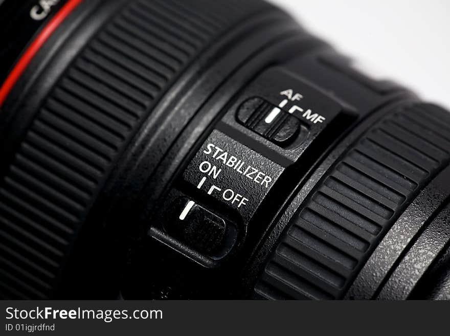 A close-up view of the controls on a camera zoom lens. A close-up view of the controls on a camera zoom lens