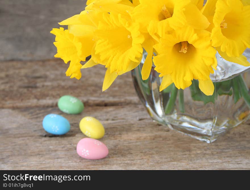 Daffodils in a vase with fake Easter eggs on the side to celebrate the holiday.  Used a selective focus and shallow depth of field. Daffodils in a vase with fake Easter eggs on the side to celebrate the holiday.  Used a selective focus and shallow depth of field.