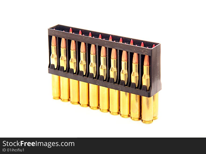 Gold bullets with red tips in holder on white