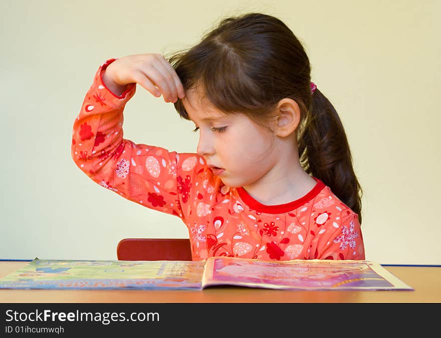 Thoughtful 5 years old girl reads magazine. Thoughtful 5 years old girl reads magazine