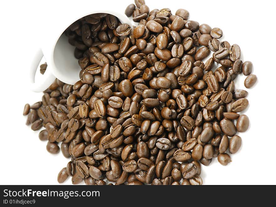 Photo of coffee beans spilling out of a white cup. Photo of coffee beans spilling out of a white cup.