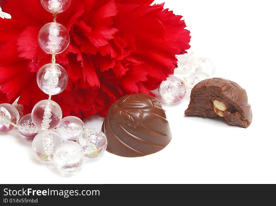 Red flower and black chocolate on white background. Red flower and black chocolate on white background