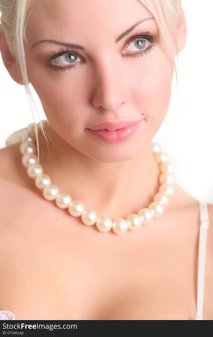 Portrait of the beautiful blonde with a pearl beads on a neck. Portrait of the beautiful blonde with a pearl beads on a neck