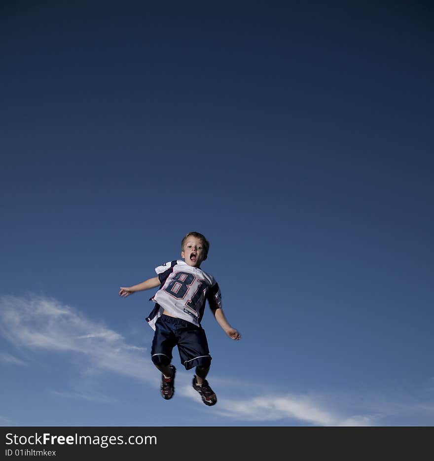 A girl poses against the sky at the top of a mountain. A girl poses against the sky at the top of a mountain