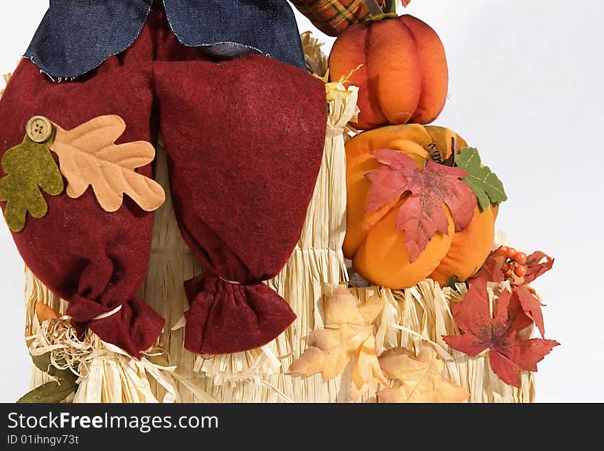 Isolated shot of scarecrow legs sitting on a bale of hay.