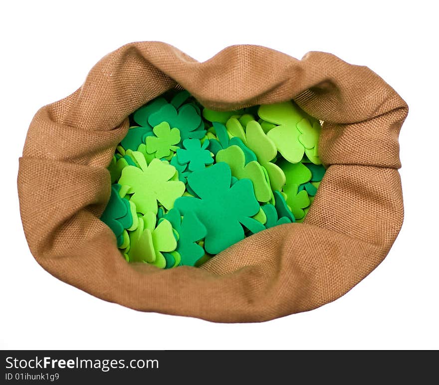 Bag of craft shamrocks on white background.