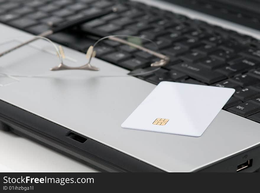 Detail of a laptop with a code card and glasses, data. Detail of a laptop with a code card and glasses, data