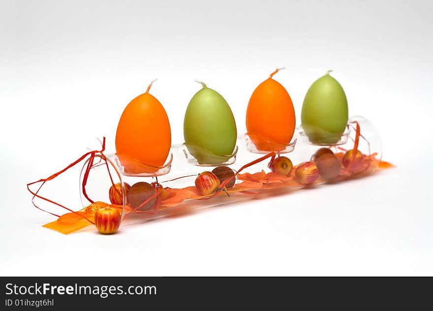 A composition of a glass tube with egg formed candles and a bit of spring feeling for easter. A composition of a glass tube with egg formed candles and a bit of spring feeling for easter.