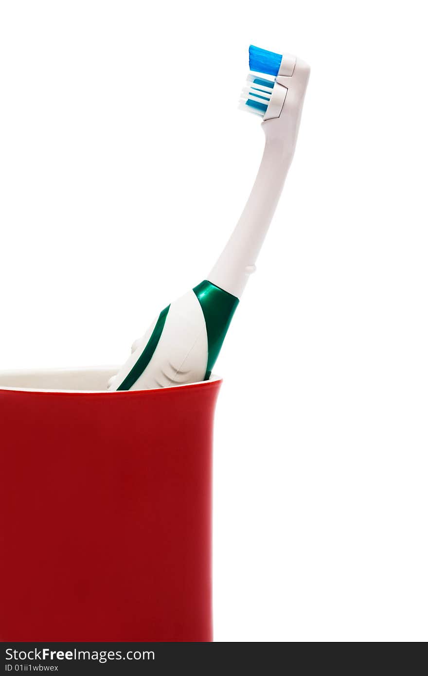 Toothbrush in a red glass on a white background