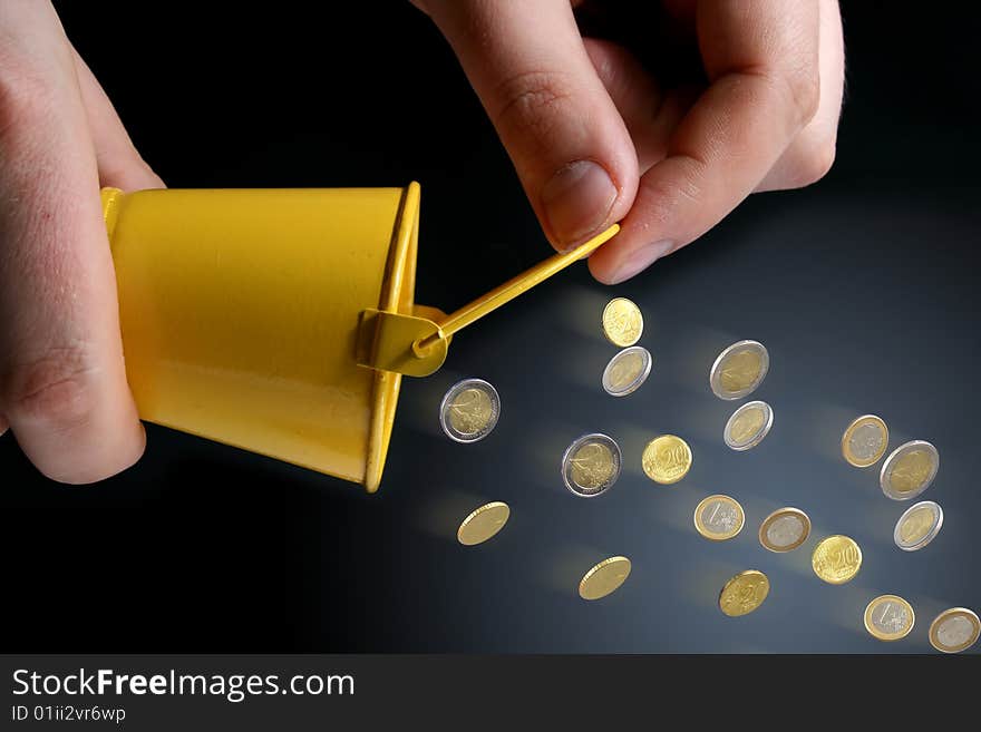 Bucket in hands and coins. Business concept.