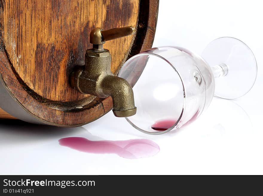 A red wine barrel, isolated in white. Wine was spilled from the tap.