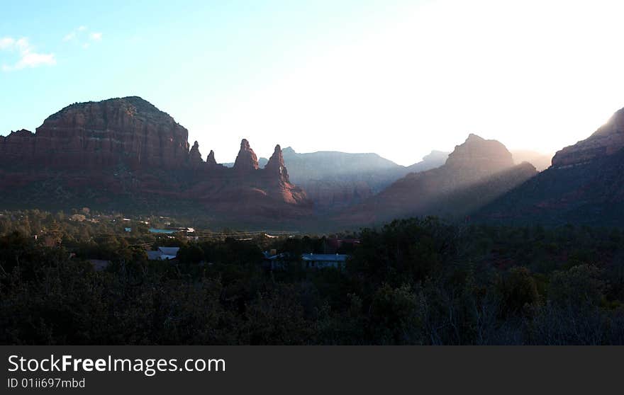 Sun beams break past some rock formations during sunrise in Sedona Arizona. Sun beams break past some rock formations during sunrise in Sedona Arizona