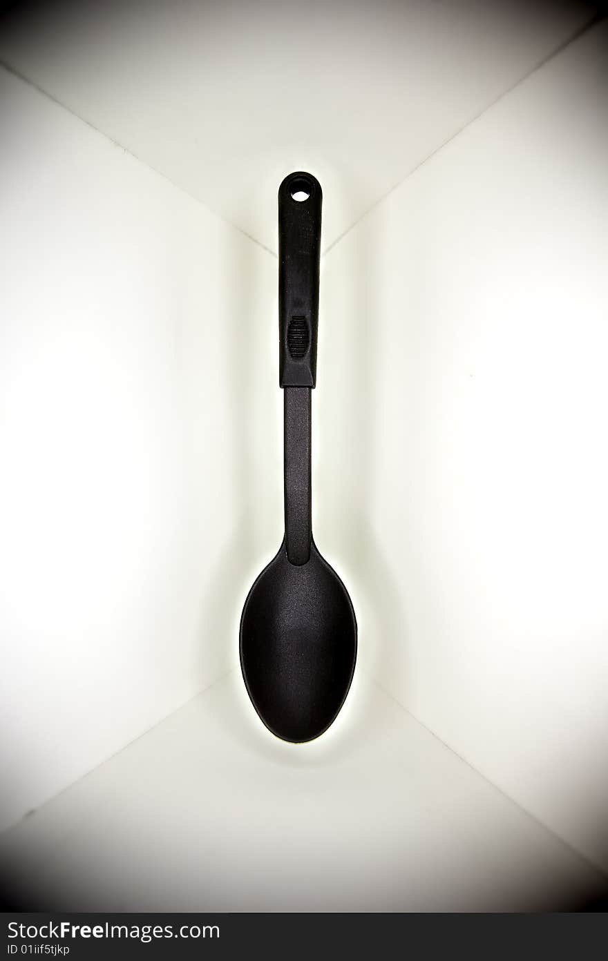 Black plastic spoon, floated in a white cornered background, with a surrounding shadow. Black plastic spoon, floated in a white cornered background, with a surrounding shadow.