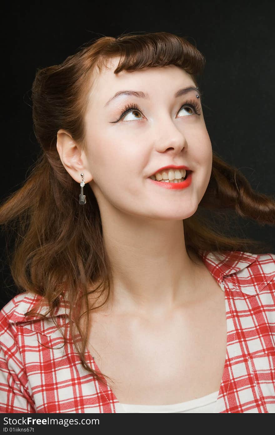 Pretty retro-style woman smiling and looking up over dark background. Pretty retro-style woman smiling and looking up over dark background