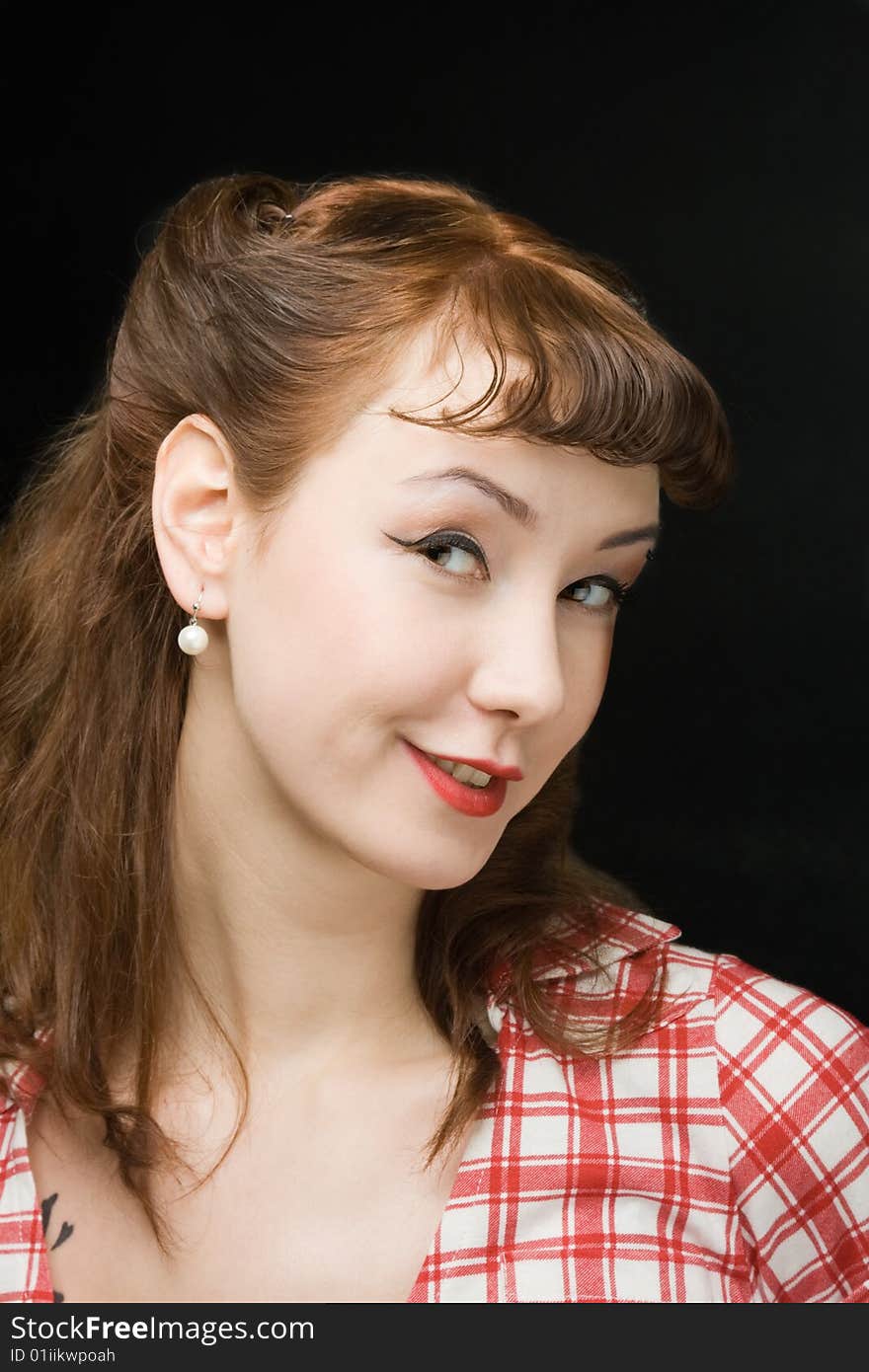 Pretty retro-style woman looking coquettishly at camera over dark background. Pretty retro-style woman looking coquettishly at camera over dark background