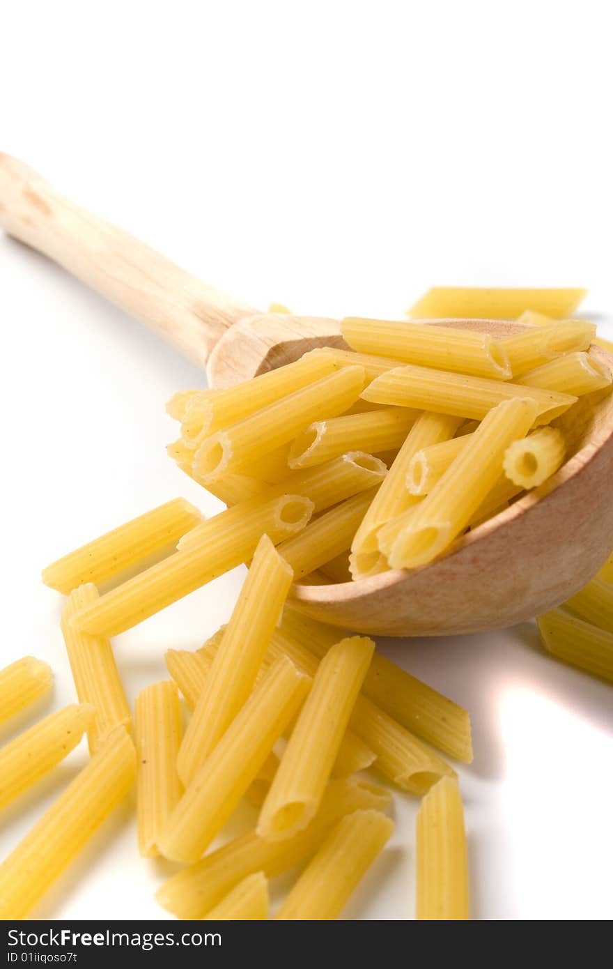 Raw italian macaroni in wooden spoon on white background