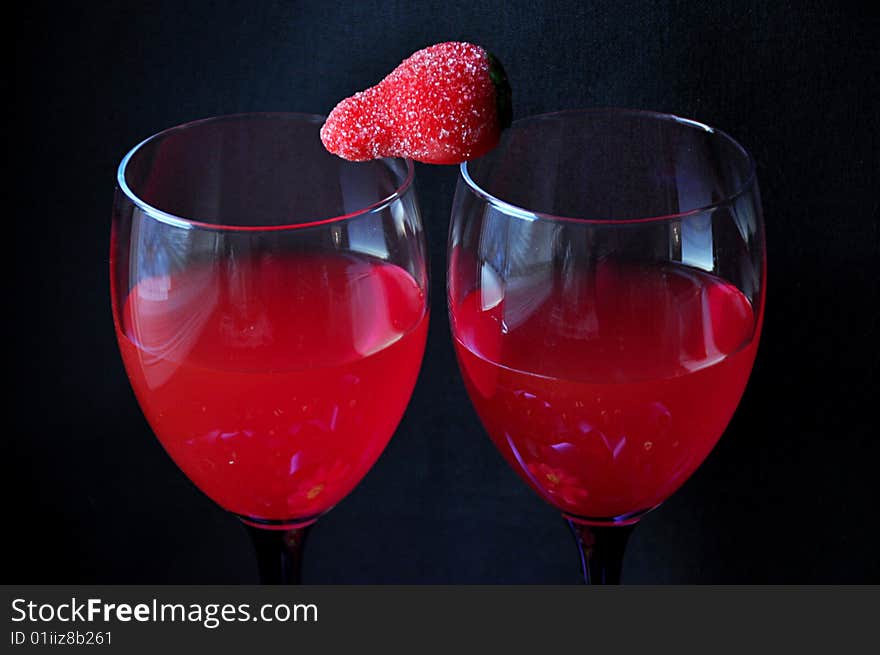 Strawberry on the glasses of wine. Marchpane, candies