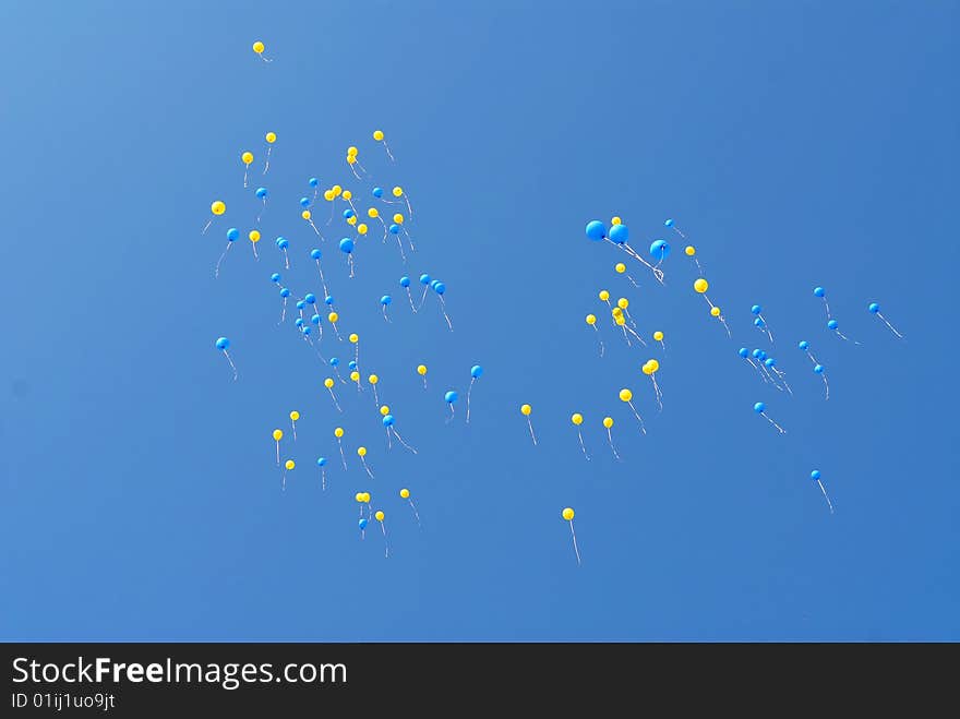 Blue and yellow balloons fly