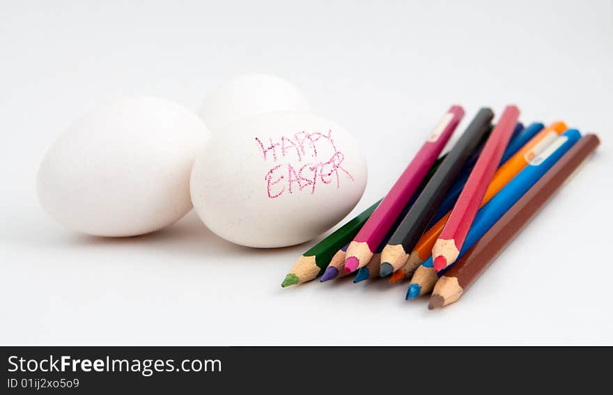 Still life of white eggs in the process of being decorated with color pencils and crayon for Easter. Still life of white eggs in the process of being decorated with color pencils and crayon for Easter