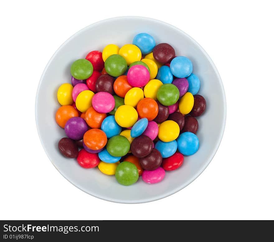 Close-up of colored candy in a bowl, isolated on a white background