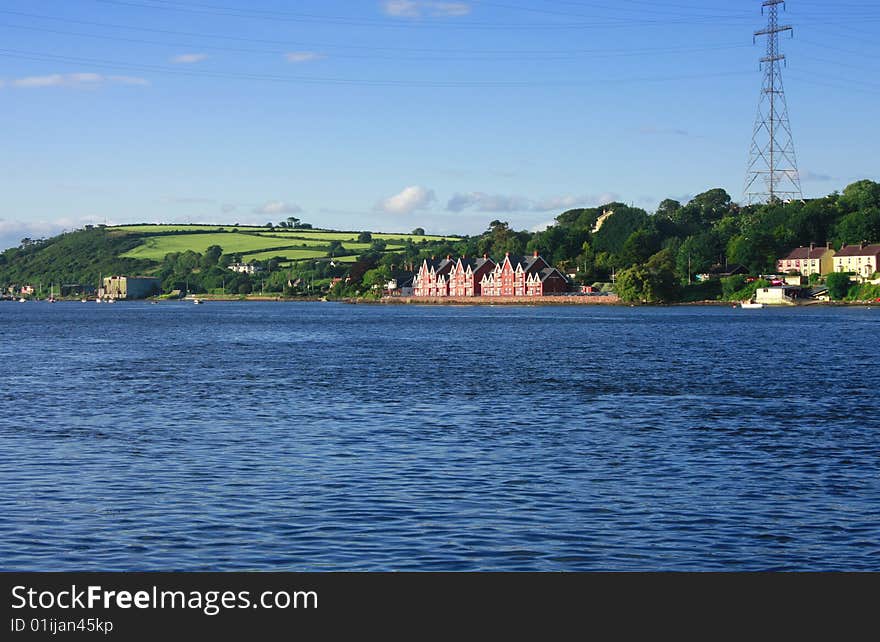 Landscape with mansion near sea shore green fields and power line