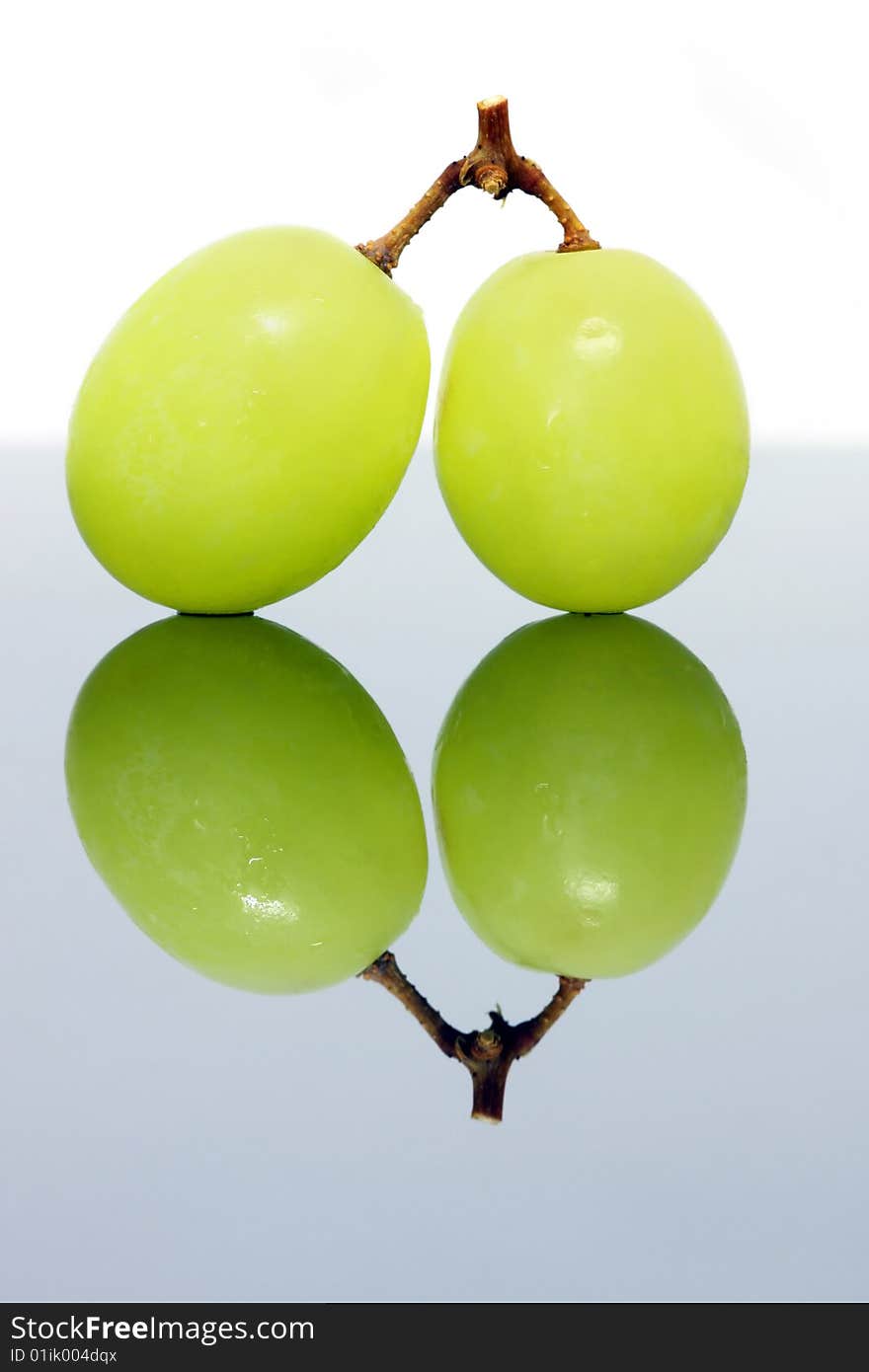 Close up of two green grapes isolated over white background.