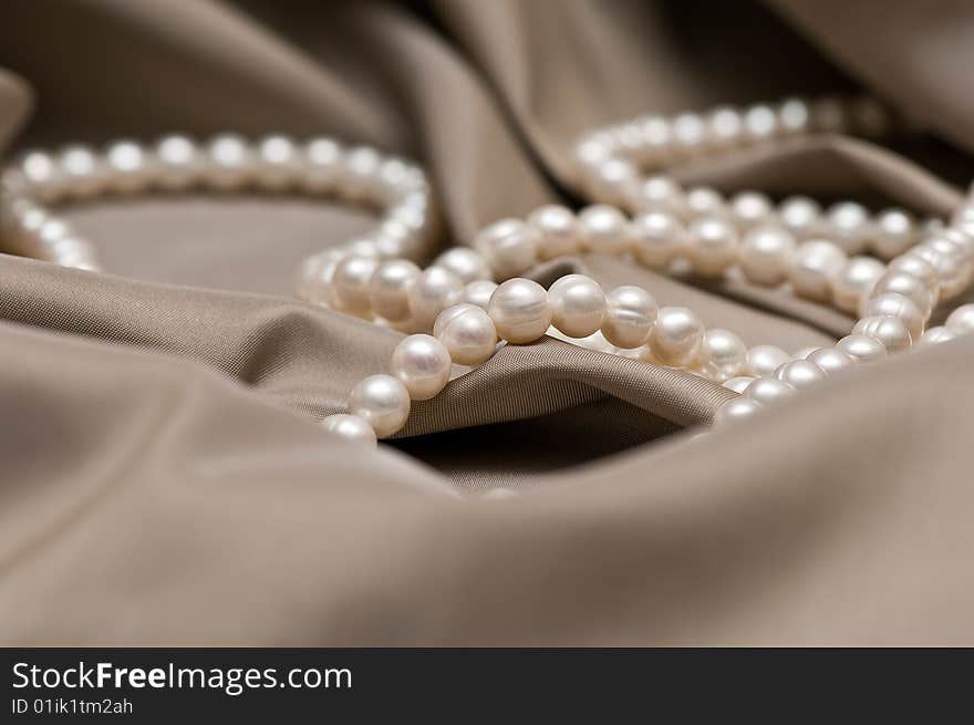 Beads of pearl on the brown background