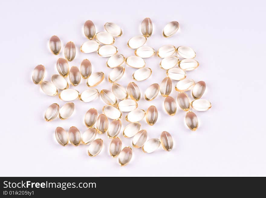 Pills of vitaminsl on the light-coloured background