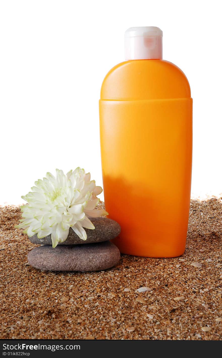 Antisun cream and flower on marine sand and white background