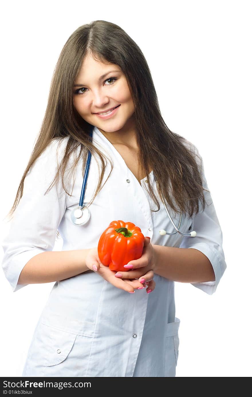 Beautiful young doctor wearing white uniform holding a red pepper in her hands. Beautiful young doctor wearing white uniform holding a red pepper in her hands