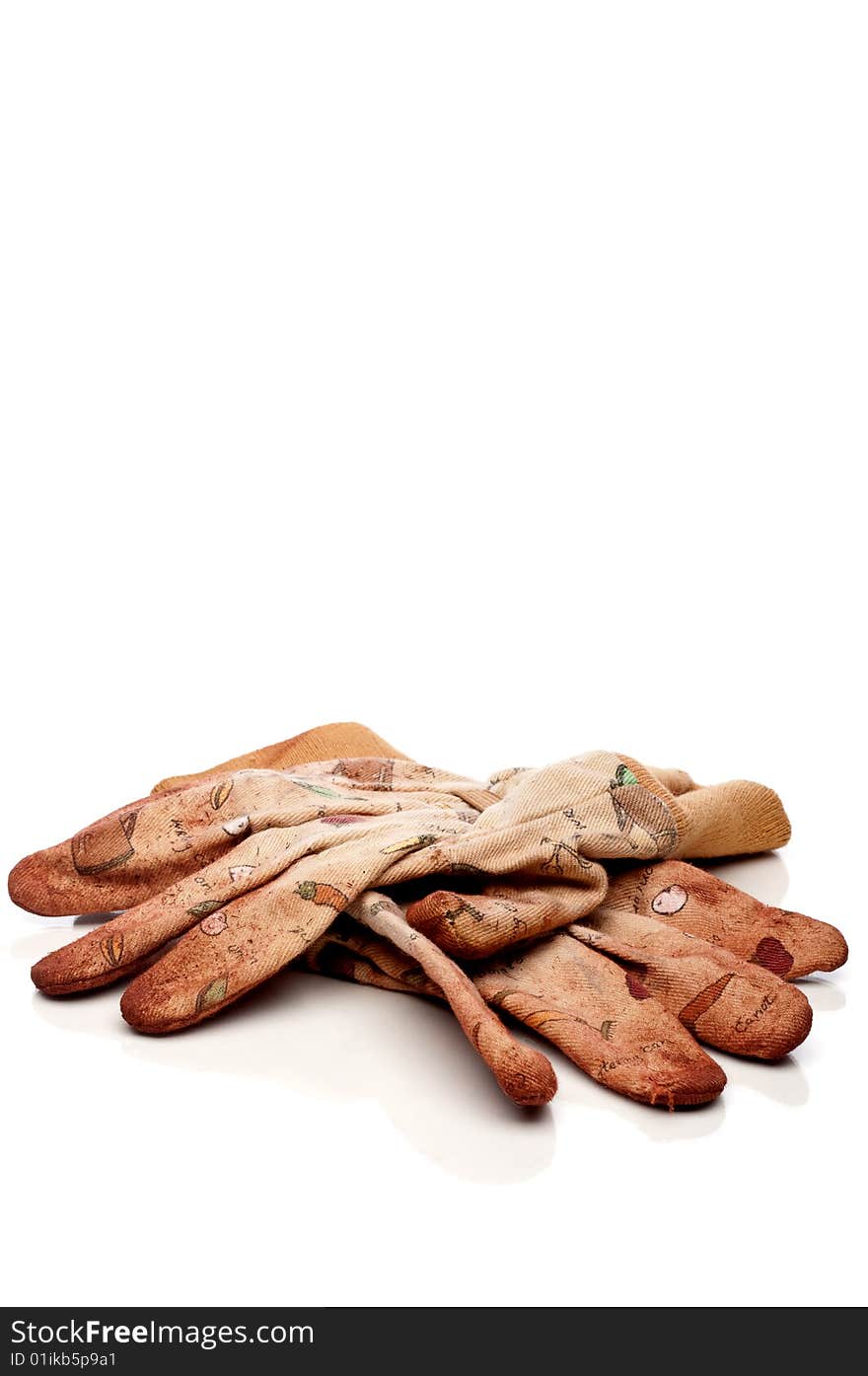 Vertical view of old worn work gloves on reflective white surface