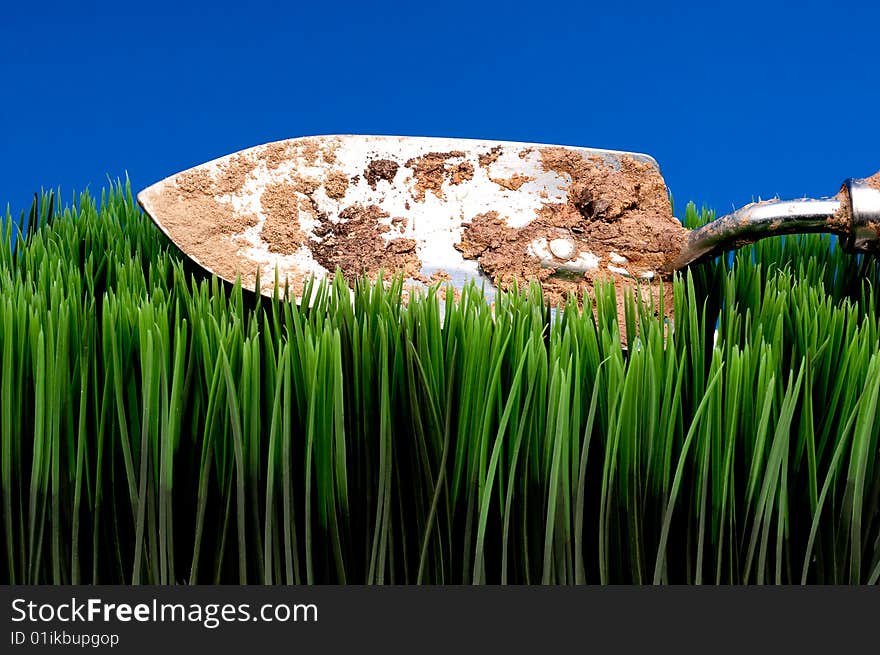 Dirty garden spade on grass